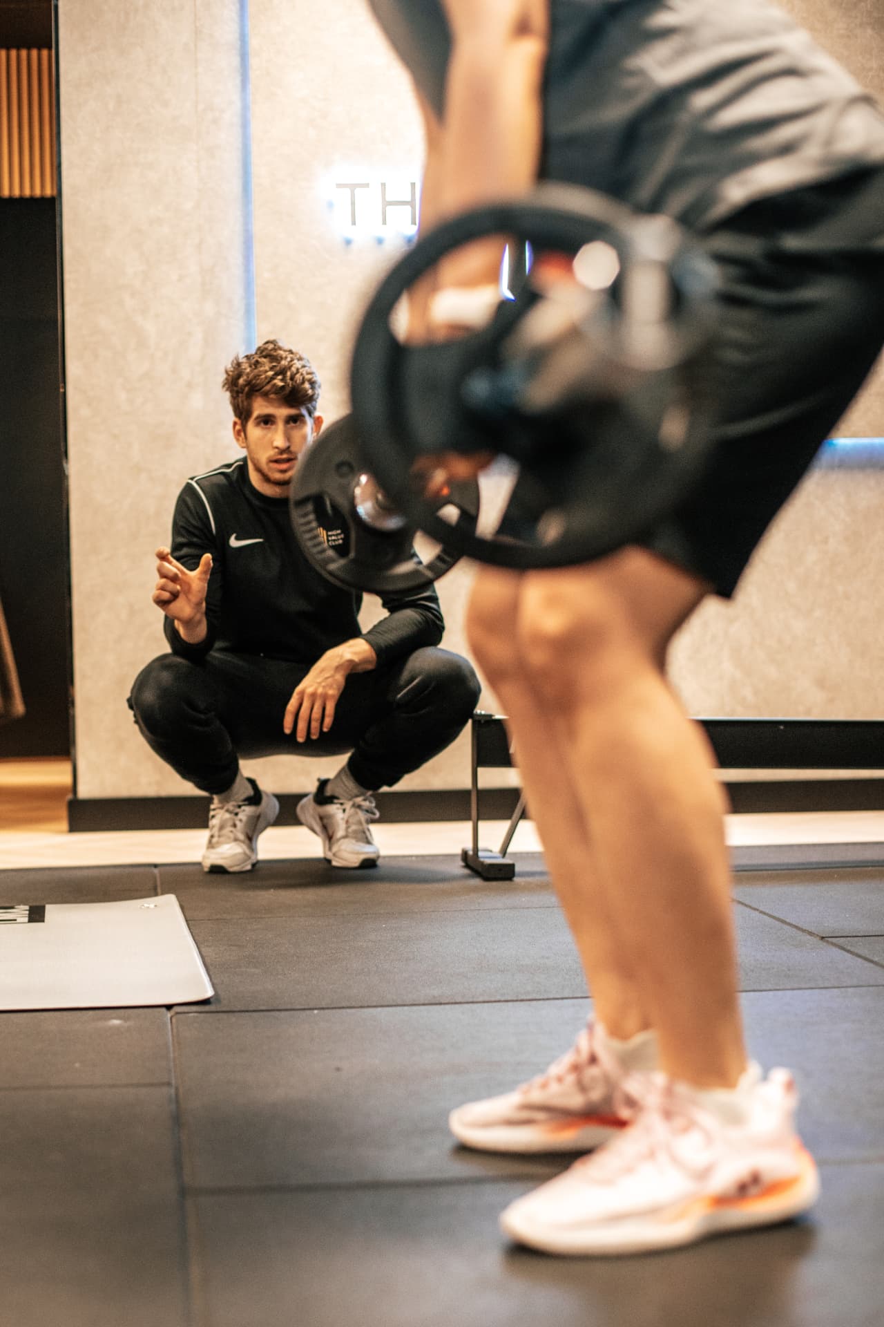 Coach observeert en corrigeert een member tijdens een oefening bij The High Value Club